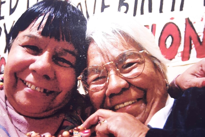 two older women hugging and smiling