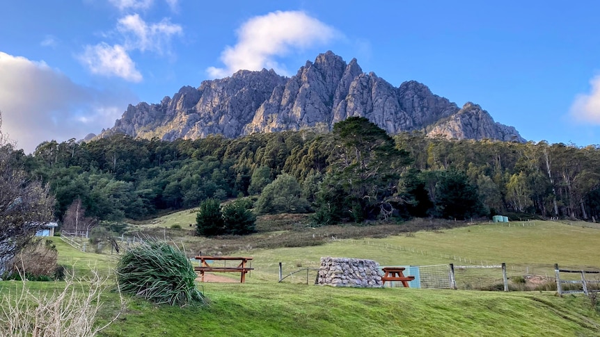 A large mountain towers over a camping ground.