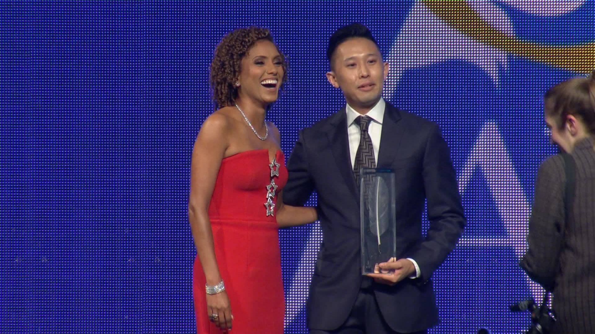 A man and woman posing for a photo on a stage