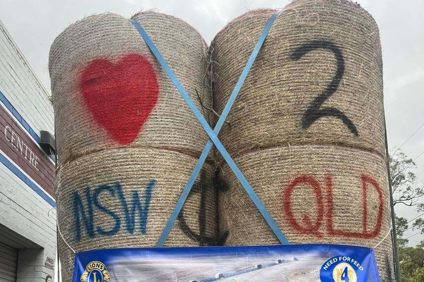spray painted hay bales reading 'love to NSW and QLD'