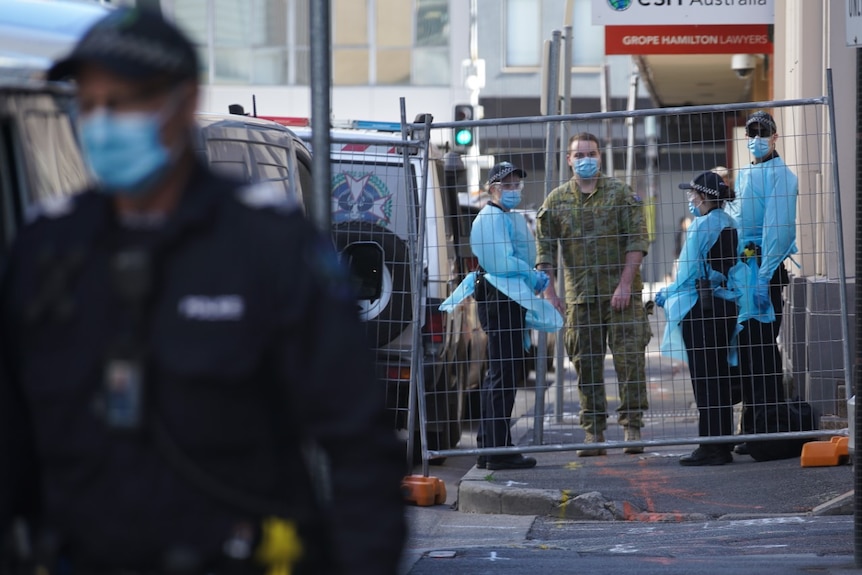 Police officers in full PPE standing with an ADF officer on an Adelaide street