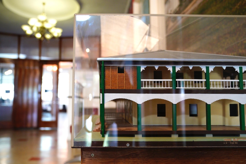 A cabinet encasing a model of an old, two-story, Queensland pub