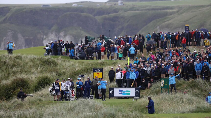 A golfer hits his tee shot on a hole surrounded by deep rough at the Open at Royal Portrush.