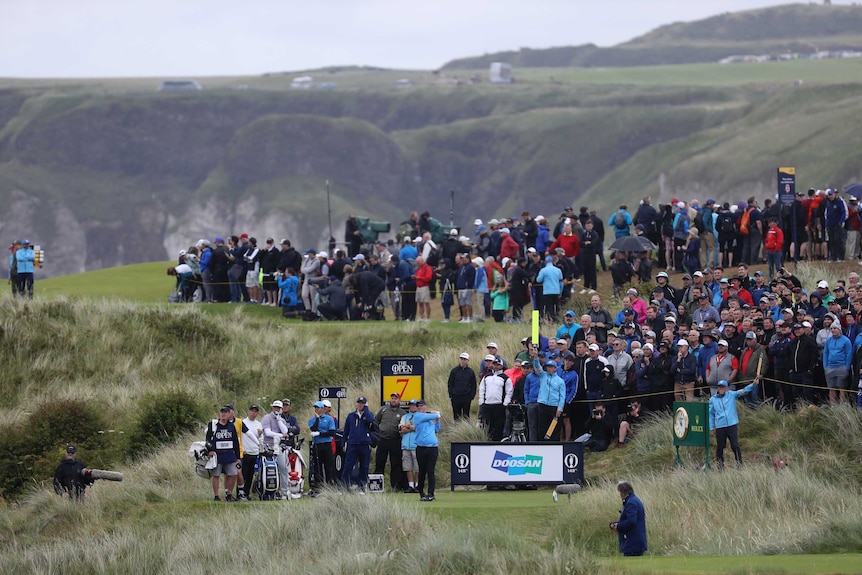 A golfer hits his tee shot on a hole surrounded by deep rough at the Open at Royal Portrush.