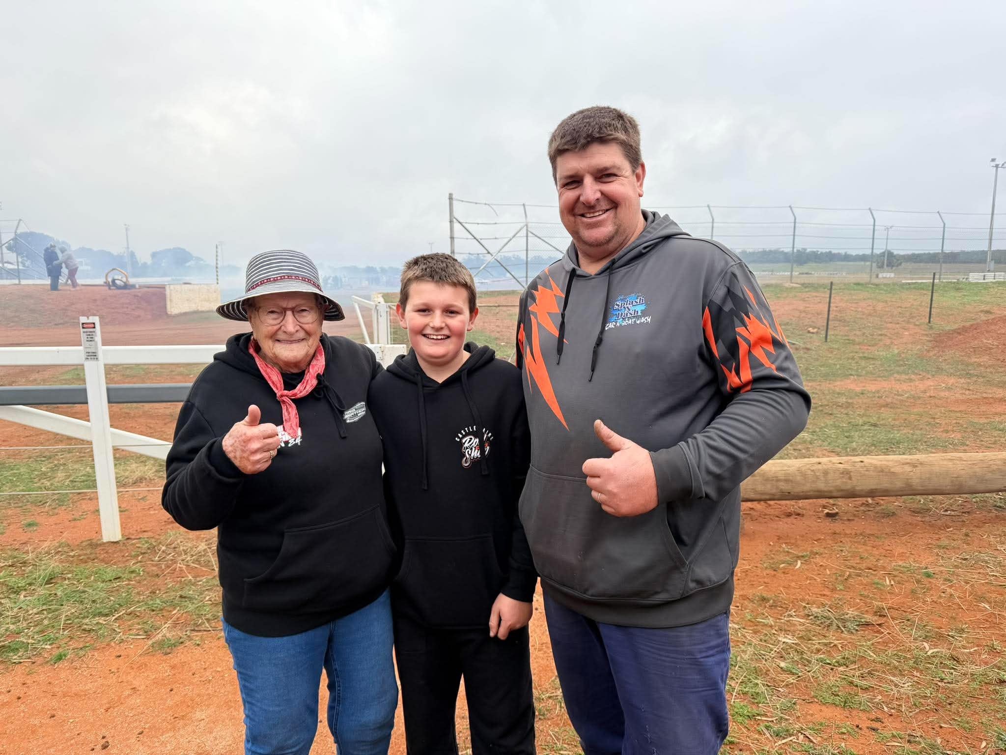 A woman and young boy both in black jumpers next to a man with a grey jumper with orange lightening bolts