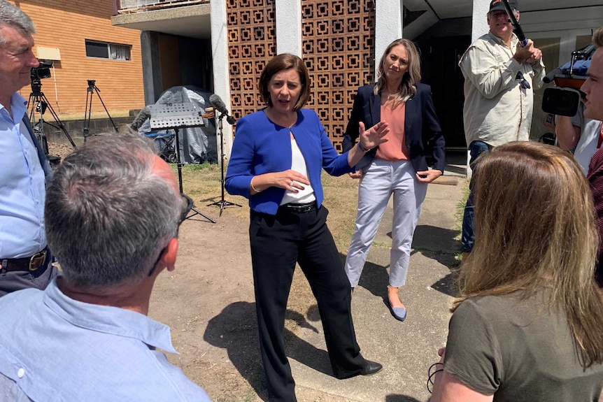 Den Frecklington outside some old apartments surrounded by media and candidates