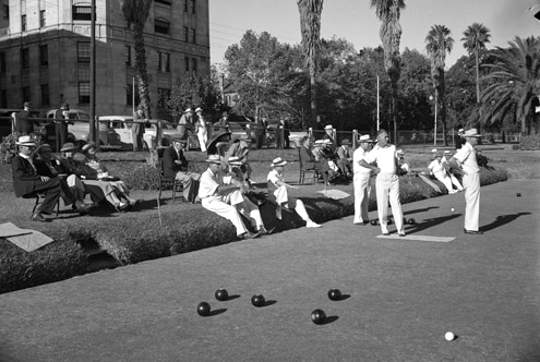 Men watching lawn bowls in 1950.