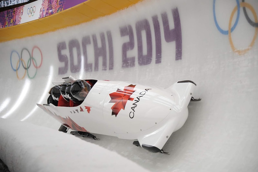 A bobsled travelling through a course with the words 'SOCHI 2014' in the background.