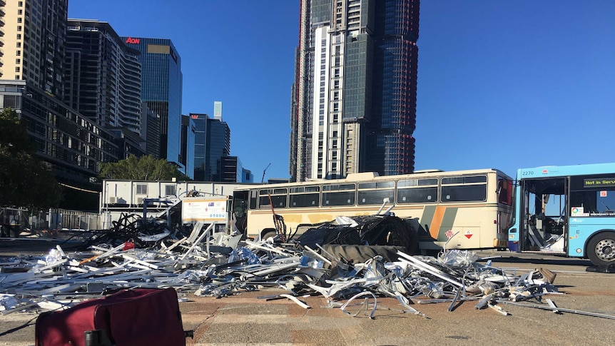 A damaged bus and strewn luggage