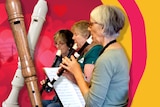 Graphic with recorders on the left and a group of women playing recorders on the right.