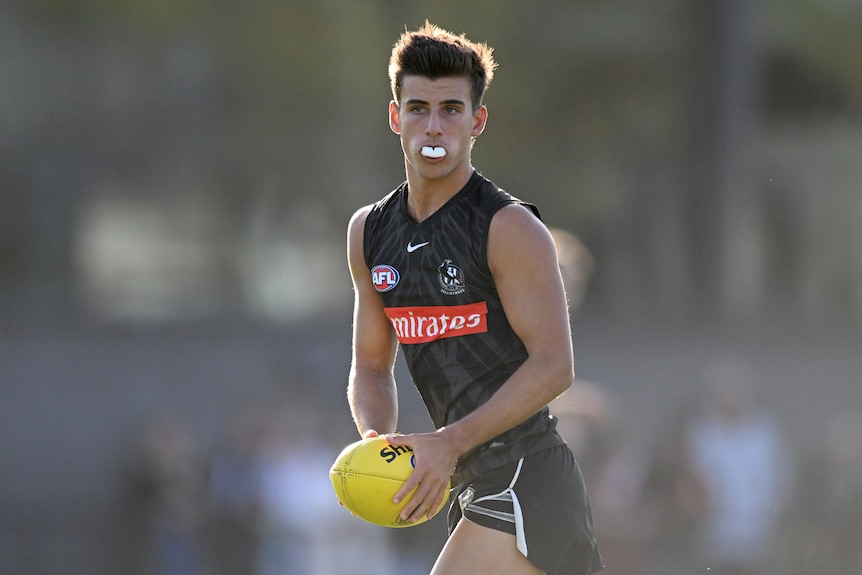 Nick Daicos looks up while running with the ball