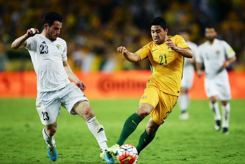 Massimo Luongo of the Socceroos is challenged by Yousef Ahmad Mohammad of Jordan