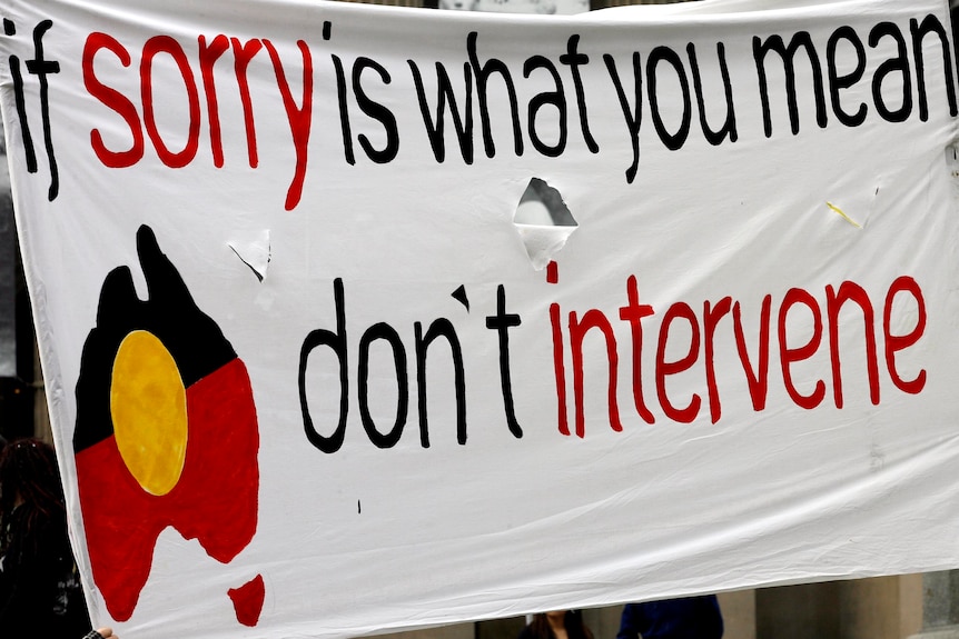 A banner at a rally calls for an end to the Northern Territory intervention.