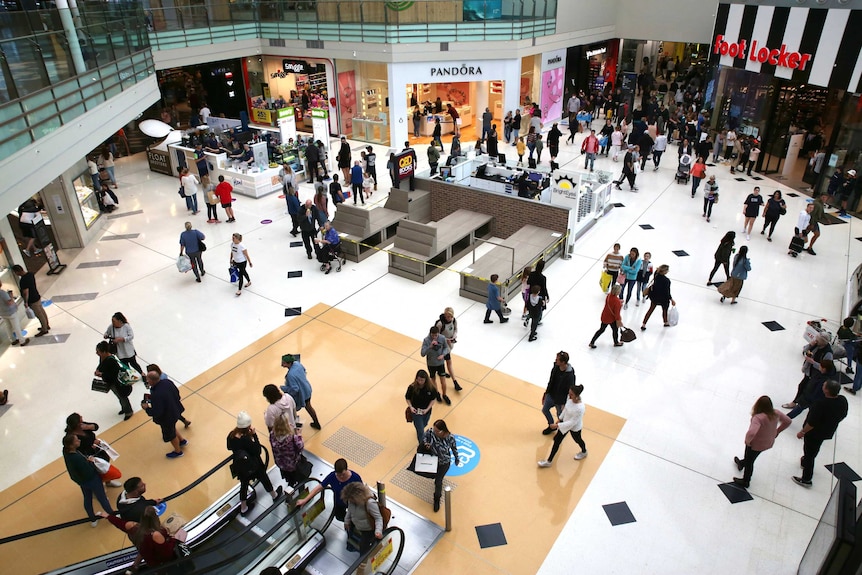 A high and wide angle looking down on crowds at Lakeside Joondalup shopping centre. Its brightly lit