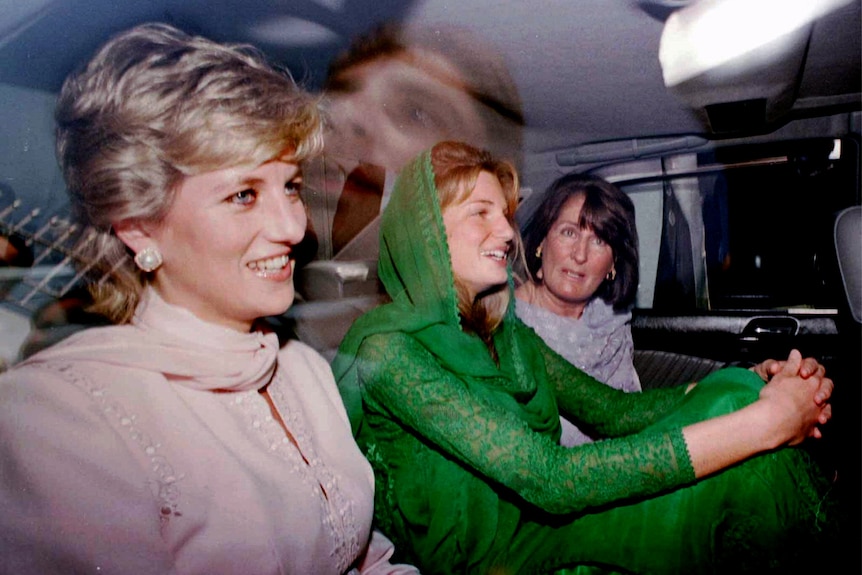 princess diana in a car with two other women. they are smiling and it looks like theyre chatting. photo taken through window