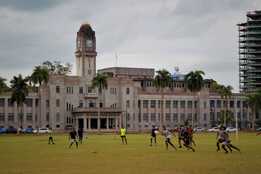 People playing rugby in front ot Fiji's parliament building.