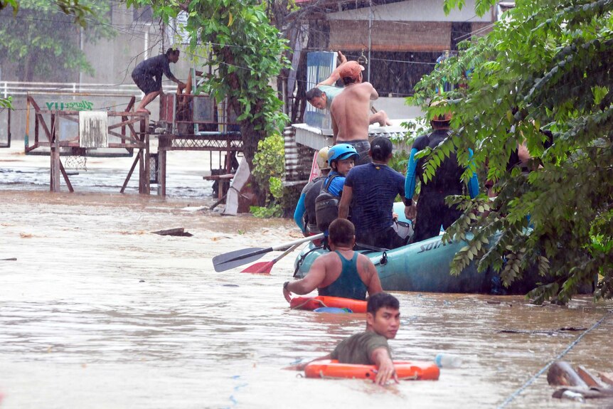 Rescuers evacuate residents from their homes during heavy flooding in Cagayan de Oro city in the Philippines.