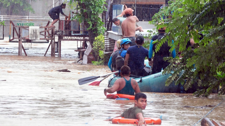 Rescuers evacuate residents from their homes during heavy flooding in Cagayan de Oro city in the Philippines.