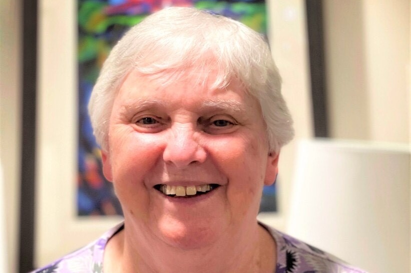 A headshot of a woman smiling in a residential setting.