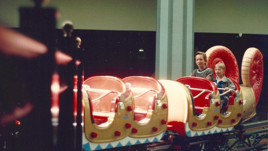 Two young boys on the back of the dragon coaster in Top's