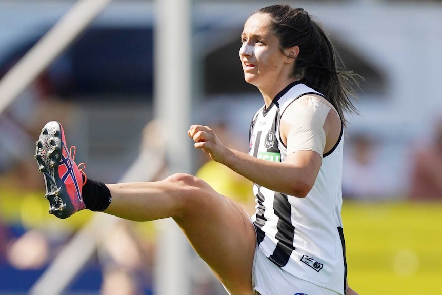 Jordan Membrey kicks a ball with her right foot during a Collingwood versus Carlton AFLW match.