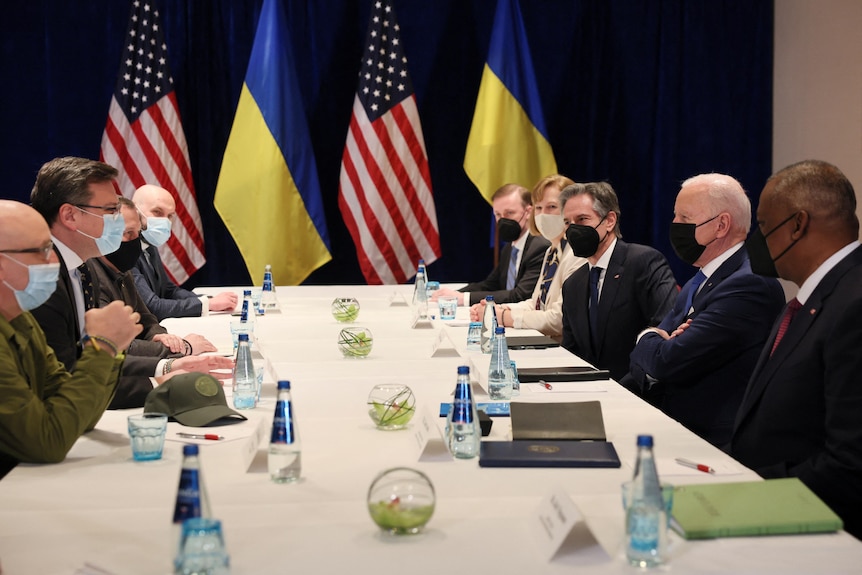 US and Ukrainian officials seated opposite each other along long table.
