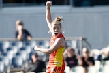 A Gold coast Suns AFLW player celebrates kicking a point after the siren that helped defeat Richmond.