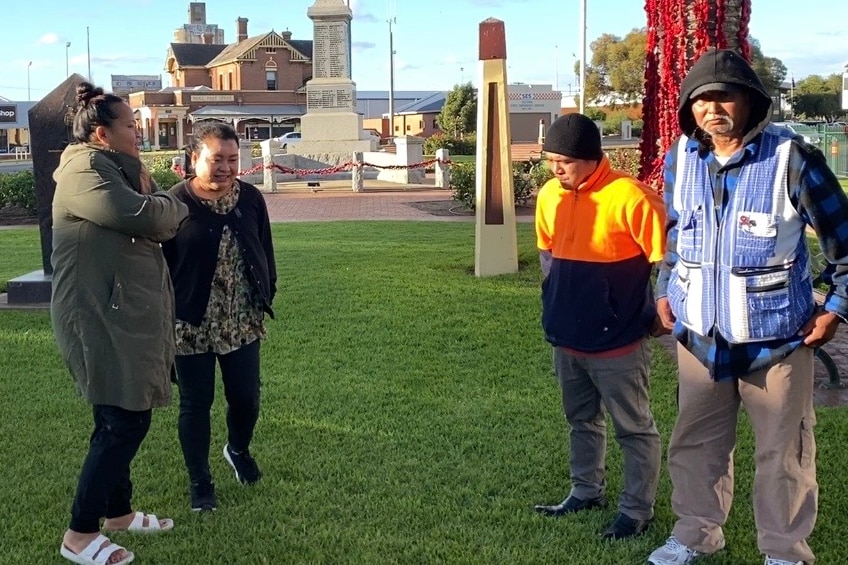Four ethnic Karen people standing at a war memorial.