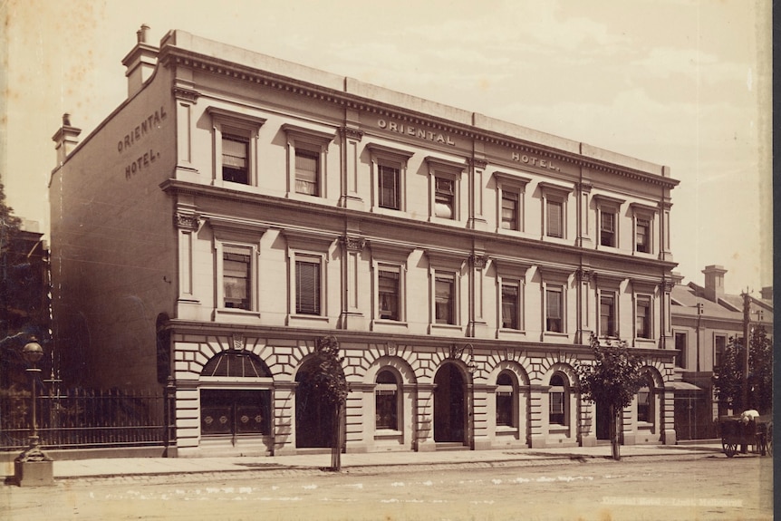 A black and white picture of a two-storey hotel with the name Oriental written on the side.