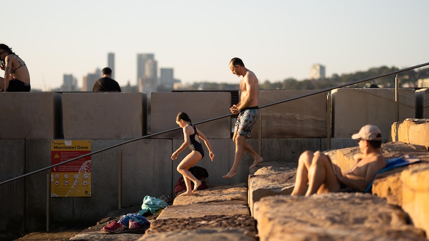 Man and child walking down steps in the sunshine beating the heat in hot Sydney