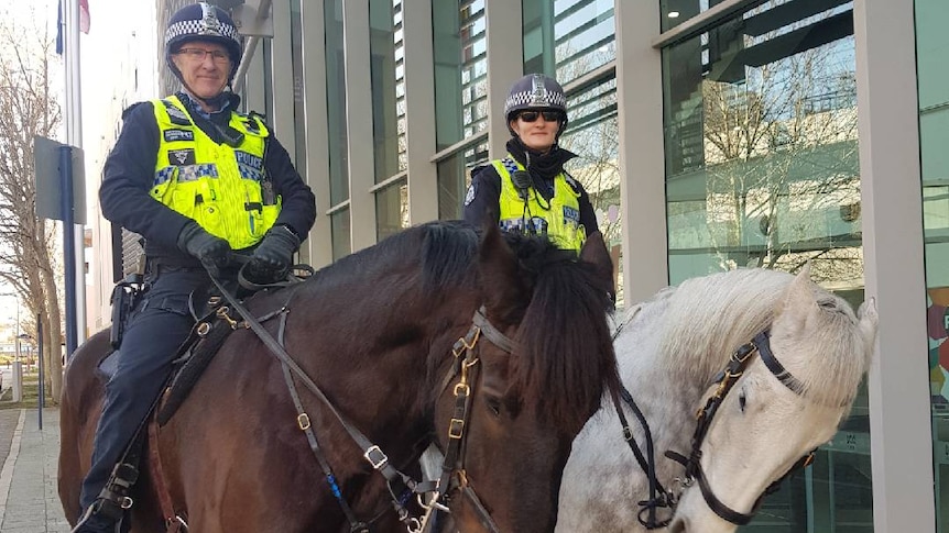 Senior Sergeant Glen Potter with Dexter the horse, and Sergeant Kerrie Bennett with Marv