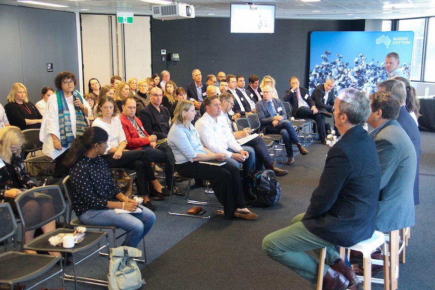 An audience asks a panel from the cotton industry some questions about sustainability.