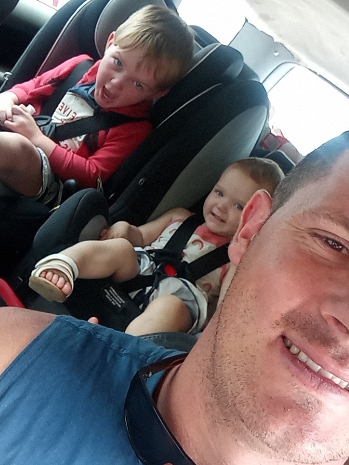A man and two children in a car.