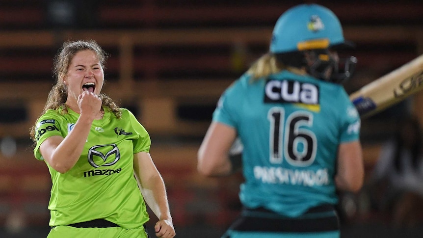 A WBBL bowler pumps her fist in celebration after taking a wicket as the batter looks away.