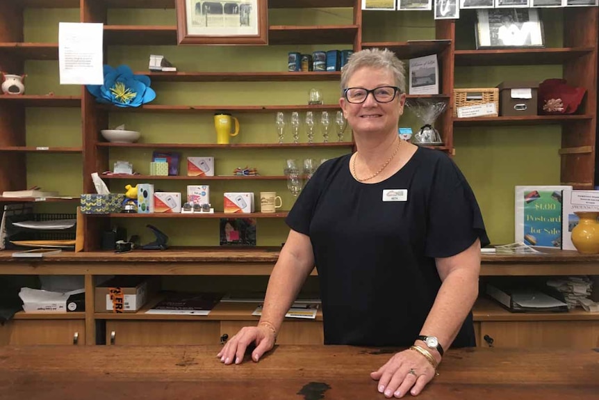 A woman stands at a counter in a community resource centre in Tambellup, WA