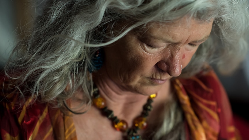 Bird's eye shot of older woman in bright red and orange dress