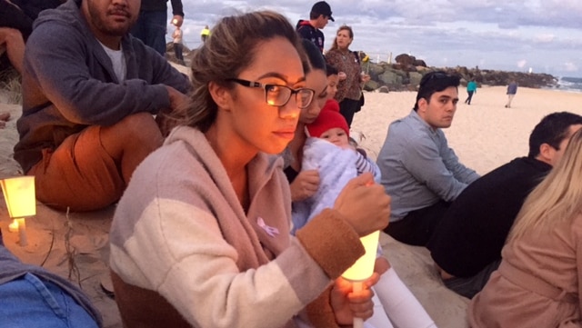 A woman attends a candle light vigil for domestic violence on the Gold Coast