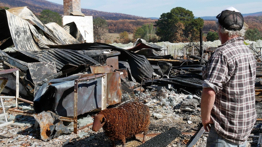 Andrew Clarke stands in front of his burnt down cellar door.