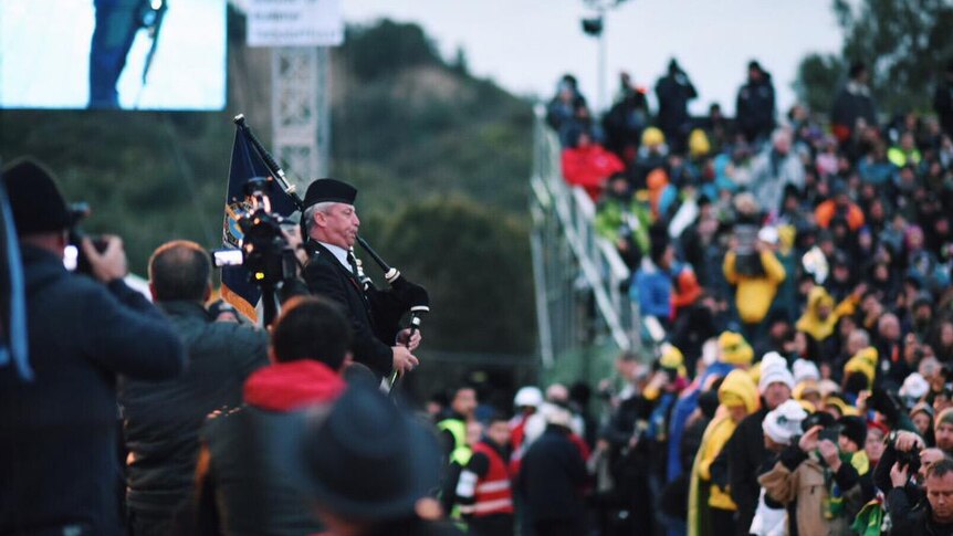 A lone piper plays as wreaths are laid at Anzac Cove