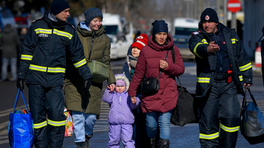 Romanian firefighters help refugees fleeing the conflict from neighbouring Ukraine after crossing the border.