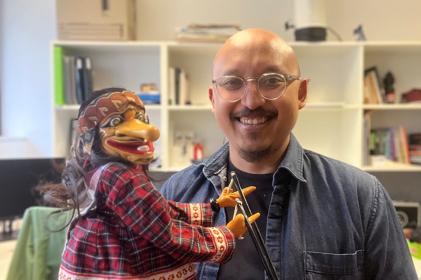 Tito is shown here with his Indonesian puppet, Petruk which is used to tell stories in West Java, where he grew up.