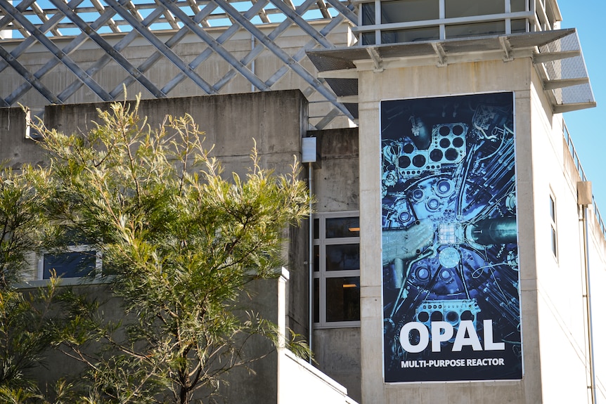 The bright blue signage says "OPAL" and "MULTI-PURPOSE REACTOR" on a concrete wall