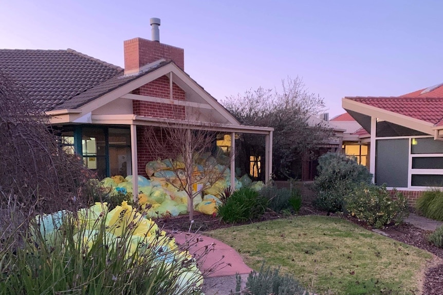 Aged care home with large collection of plastic bags on verandah and pathway