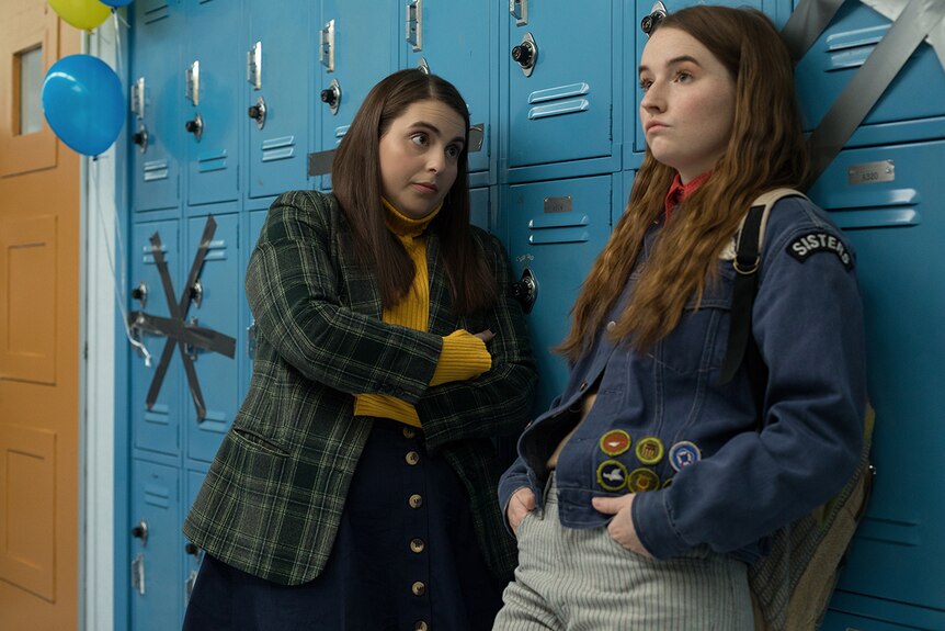 Colour film still of Beanie Feldstein and Kaitlyn Dever leaning against school lockers in 2019 film Booksmart.