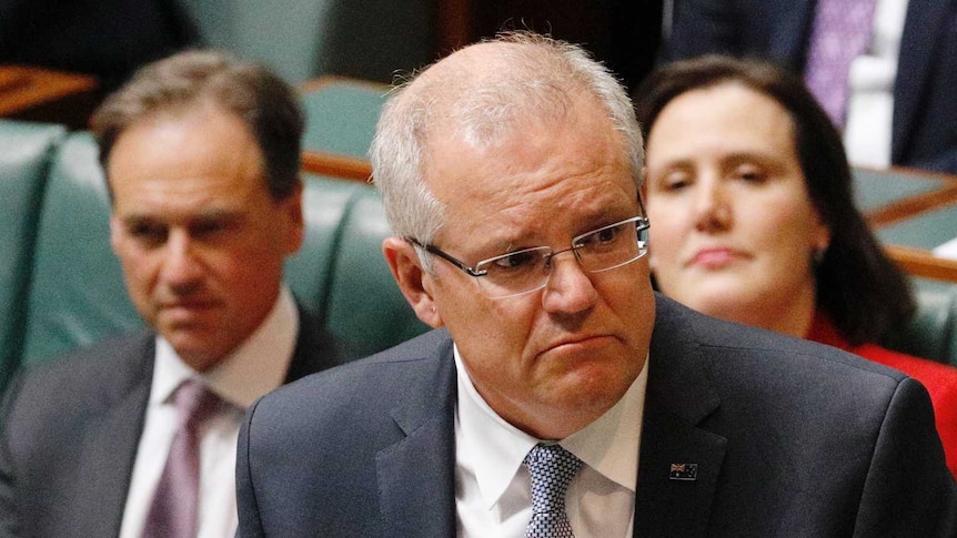 Scott Morrison stands at the despatch box frowning during Question Time