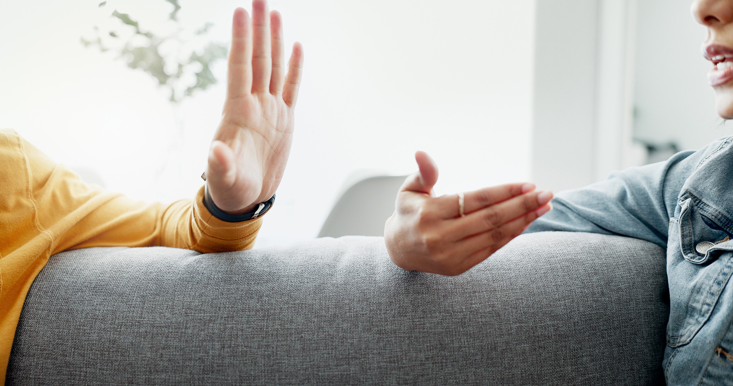 man and woman arguing on couch, close up of hands