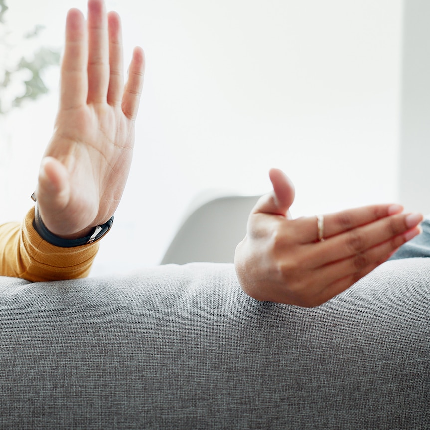 man and woman arguing on couch, close up of hands