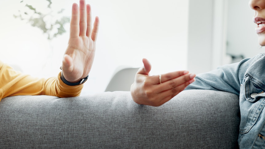 man and woman arguing on couch, close up of hands