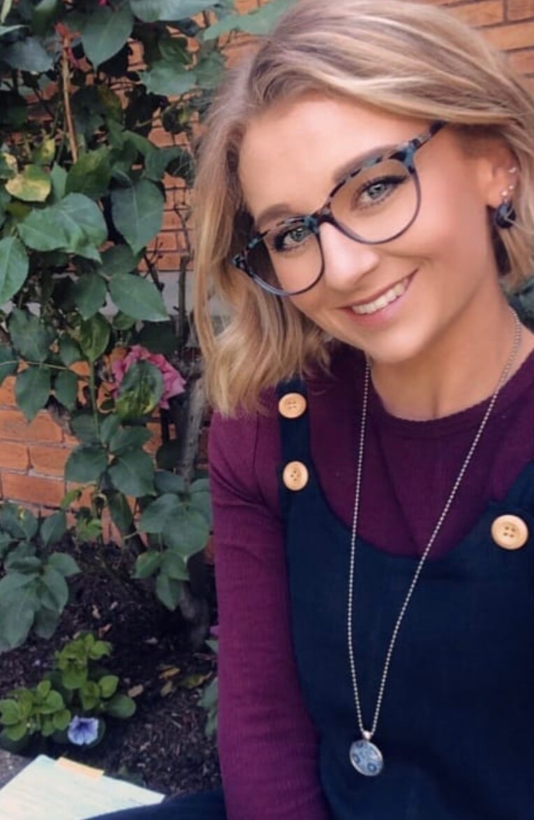 A young blonde woman wearing glasses 