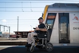 Wheelchair users Andrew Emmerson waits for his train on the platform at Sydenham train station in Sydney.